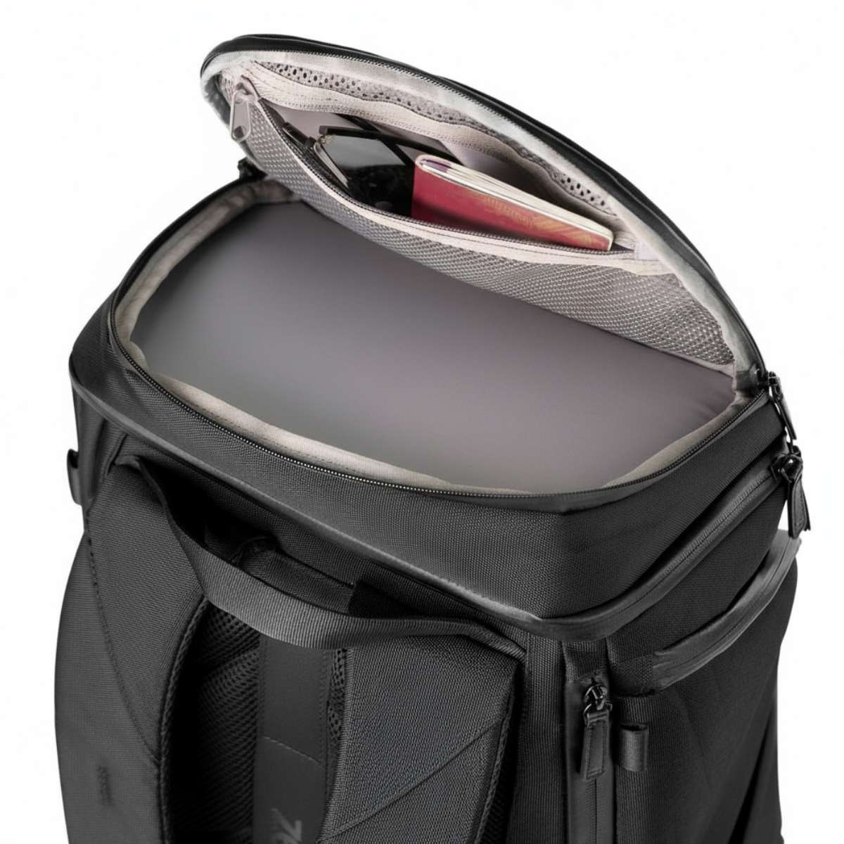 Zbliżenie z góry czarnego plecaka z otwartą górną komorą, widoczne uporządkowane wnętrze.