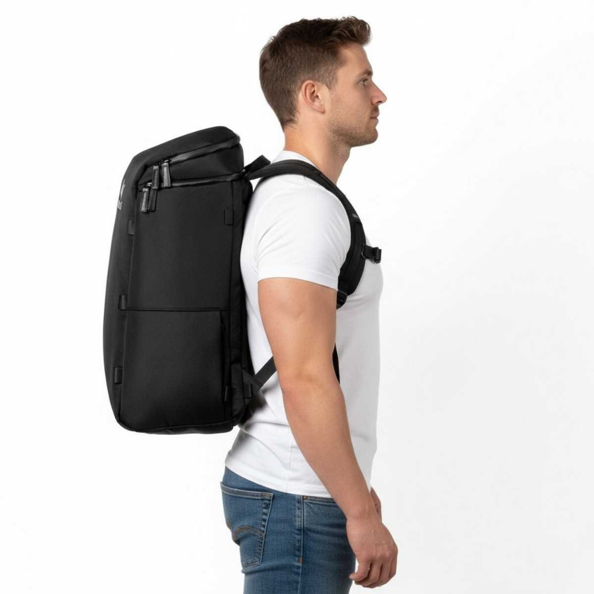 Mężczyzna w białej koszulce i dżinsach prezentuje plecak Zeeksack w profilu, studio na białym tle.